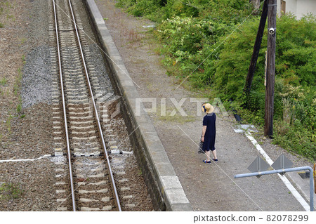 Taking a portrait of a woman at JR Kakarima Station in Mori-cho, Hokkaido in autumn 82078299
