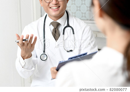 A smiling young male doctor in a white coat (medical worker / doctor) A smiling young male doctor in a white coat (medical worker / doctor) 82080077