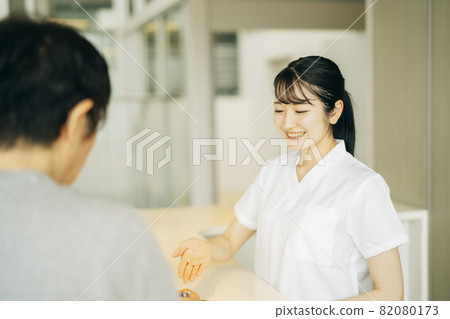 Woman (patient) at the reception desk of the hospital Woman (patient) at the reception desk of the hospital 82080173