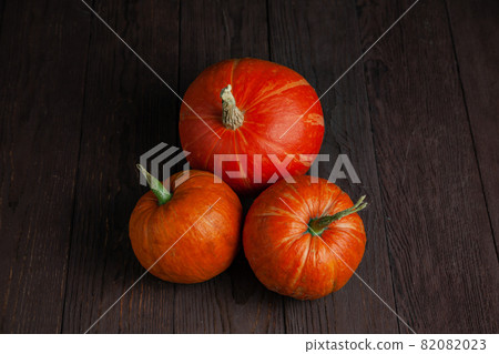 Pumpkins on wooden table in dark mood. 82082023