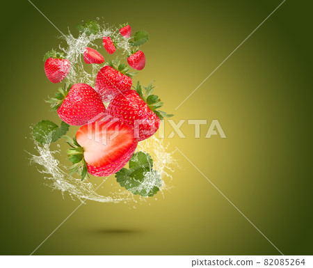 Water Splash On fresh strawberries with leaves Isolated on green Background  82085264