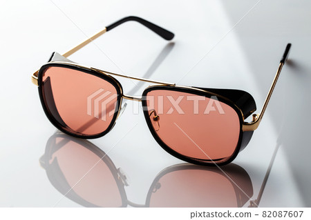 Sunglasses on a white reflective surface. Fashionable, stylish accessories Sunglasses on a white reflective surface. Fashionable, stylish accessories 82087607