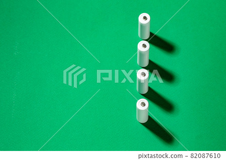White AA batteries on a green background. Space for text. 82087610