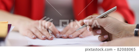 Hands of colleagues with ballpoint pen lying on documents closeup Hands of colleagues with ballpoint pen lying on documents closeup 82088065
