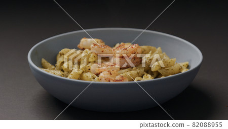 fried shrimps fall on pest penne in blue bowl on black background fried shrimps fall on pest penne in blue bowl on black background 82088955