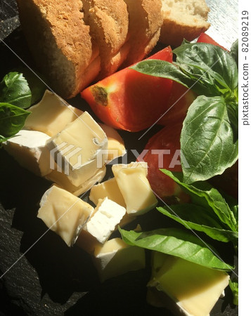 fried eggs with camembert cheese, tomatoes, basil leaves and bread. Just a hearty building in Italian cuisine fried eggs with camembert cheese, tomatoes, basil leaves and bread. Just a hearty building in Italian cuisine 82089219