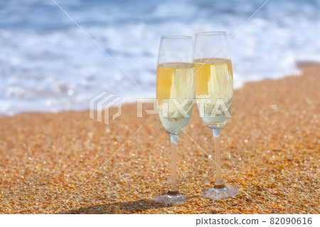 two glasses of champagne on the sea beach two glasses of champagne on the sea beach 82090616