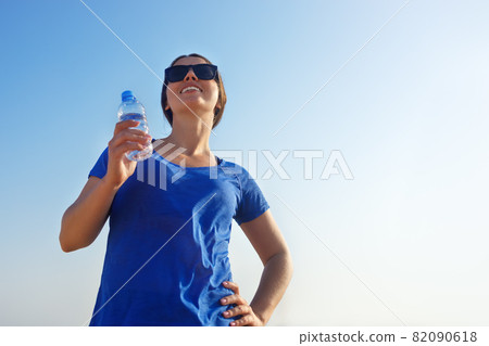 fitness woman with bottle of drinking water on the sea beach fitness woman with bottle of drinking water on the sea beach 82090618