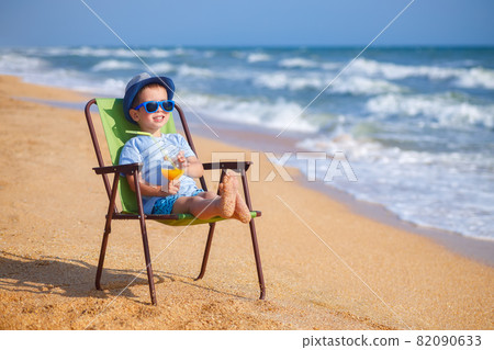 happy little boy drinking juice on sea beach happy little boy drinking juice on sea beach 82090633