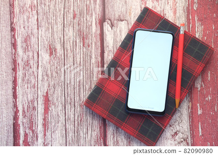top view of smart phone and notepad on table top view of smart phone and notepad on table 82090980