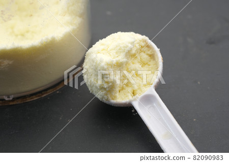 Close up of baby milk powder and spoon on tile background. 82090983