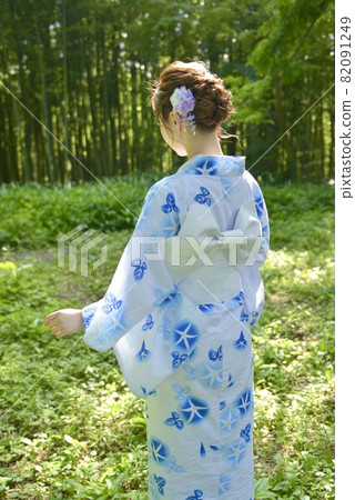 Back view of a young woman in a green forest and yukata Back view of a young woman in a green forest and yukata 82091249