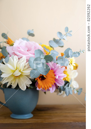 Autumnal flowers bouquet in a vase. Beautiful, colorful dahlia, roses and eucalyptus plant. Autumnal flowers bouquet in a vase. Beautiful, colorful dahlia, roses and eucalyptus plant. 82092262