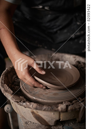 Hands of craftsman artist working on pottery wheel. 82093422