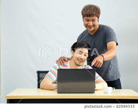 Asian Gay couple at office using internet and laptop shopping online purchase 82094333