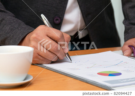 Close up young Asian businessman in black suit holding pen writing signature Close up young Asian businessman in black suit holding pen writing signature 82094427