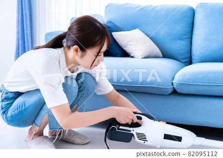 Woman vacuuming in the living room Woman vacuuming in the living room 82095112