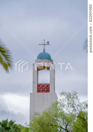 Bell tower of a small church above trees 82095460
