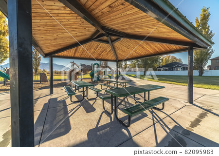 Covered picnic tables in a small urban park 82095983