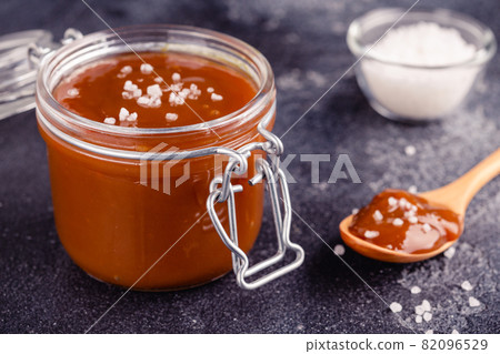 Glass jar with tasty delicious salted caramel 82096529