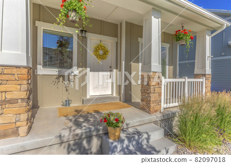 Outdoor stairs porch and white front door with wreath at the facade of a home 82097018