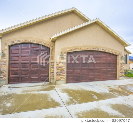 House exterior with a two car garage and concrete wall with stone bricks 82097047