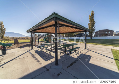Outdoors covered tables and benches for a picnic Outdoors covered tables and benches for a picnic 82097369