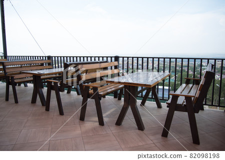 An empty terrace of a summer cafe. Great view, in the distance the sea. Empty tables An empty terrace of a summer cafe. Great view, in the distance the sea. Empty tables 82098198