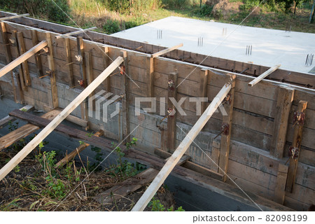 Construction site. The timber formwork is prepared for pouring concrete. The metal fittings are also visible. The process of building a private house Construction site. The timber formwork is prepared for pouring concrete. The metal fittings are also visible. The process of building a private house 82098199