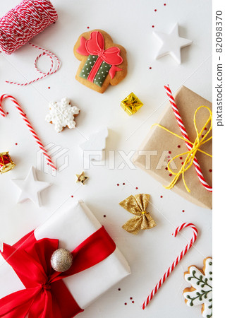 Xmas pattern. Winter holidays ornament. Festive craft set. Homemade gingerbread cookie rustic gift box candy cane red cord festive decoration isolated on white background. 82098370