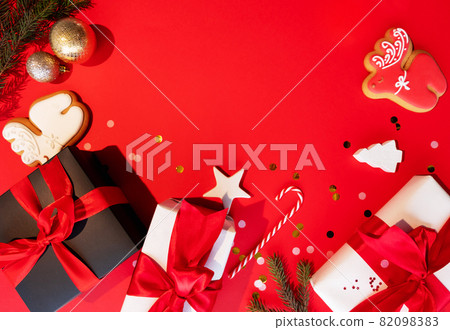 Happy New Year. Xmas background. Festive ornament. Black white gift box confetti gingerbread cookie fir tree frame holiday composition isolated on red empty space. 82098383