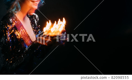Enjoying birthday. Happy woman. Festive bakery. Holiday wish. Unrecognizable pleased lady feeling amazed holding sweet cake with candle lights long exposure isolated black copy space. Enjoying birthday. Happy woman. Festive bakery. Holiday wish. Unrecognizable pleased lady feeling amazed holding sweet cake with candle lights long exposure isolated black copy space. 82098555