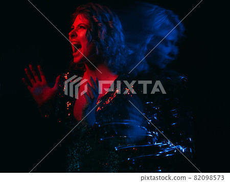 Aggressive woman. Face expression. Bipolar disorder. Split personality. Dual rage lady and depressed shape isolated black long exposure red blue neon light blur. Aggressive woman. Face expression. Bipolar disorder. Split personality. Dual rage lady and depressed shape isolated black long exposure red blue neon light blur. 82098573