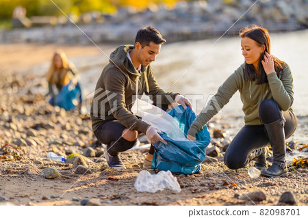 Team of dedicated and smiling volunteers collecting plastic garbage at beach Team of dedicated and smiling volunteers collecting plastic garbage at beach 82098701