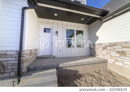 Entrance door to a white timber clad home 82098828