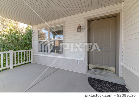 Covered front porch with grey and white decor 82099156