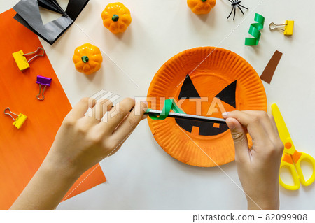 Cuts of paper for Halloween. Hand cut paper. Pumpkins. Scissors and glue. On a light background. Top view. Flat lay. DIY. Step by step 82099908