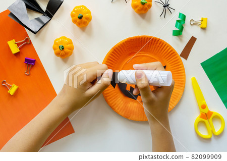 Cuts of paper for Halloween. Hand cut paper. Pumpkins. Scissors and glue. On a light background. Top view. Flat lay. DIY. Step by step 82099909