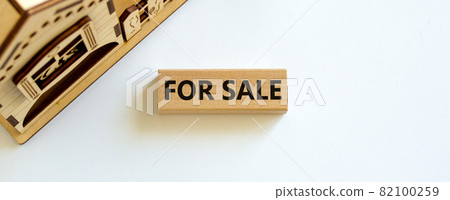 Wooden block with words 'for sale' near miniature house. Beautiful white background, copy space. Business concept. Wooden block with words 'for sale' near miniature house. Beautiful white background, copy space. Business concept. 82100259