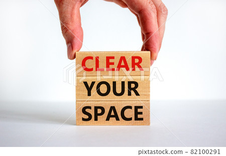 Clear your space symbol. Wooden blocks with words 'Clear your space'. Beautiful white background, businessman hand. Business, clear your space concept, copy space. 82100291