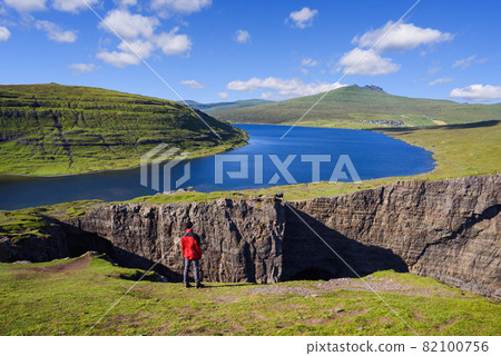 Tourist enjoys the view of Lake Sorvagsvatn on Vagar Island, Faroe Islands Tourist enjoys the view of Lake Sorvagsvatn on Vagar Island, Faroe Islands 82100756