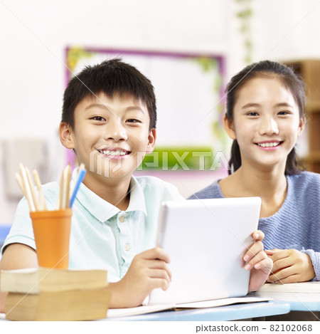 portrait of two happy asian primary school students looking at camera smiling portrait of two happy asian primary school students looking at camera smiling 82102068