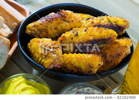 Fried chicken wings served in black bowl, two sauses and bread 82102480
