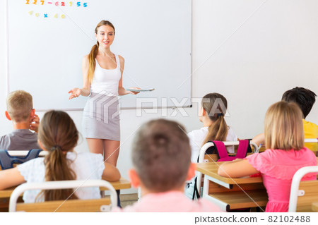 Young attractive female teacher giving lesson to children Young attractive female teacher giving lesson to children 82102488