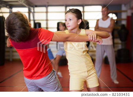 Girls and boys training self-protection moves on each other 82103431