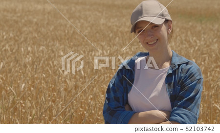 Happy girl farmer smiling in a wheat field, agriculture, successful business of sown rye plantations, grain harvest season, flour and bread production, the life of a young agronomist 82103742