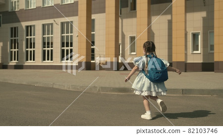 elementary school child is running around the school yard with backpack on his shoulders, small kid is first grade student, modern curriculum, an active kid on street, desire to be smart, happy girl 82103746