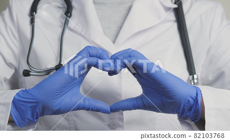 A doctor in blue gloves shows his heart, a cordiologist for a healthy outflow of blood, the services of a therapist in hospitals with the best specialists, it's time to examine the body for A doctor in blue gloves shows his heart, a cordiologist for a healthy outflow of blood, the services of a therapist in hospitals with the best specialists, it's time to examine the body for 82103768