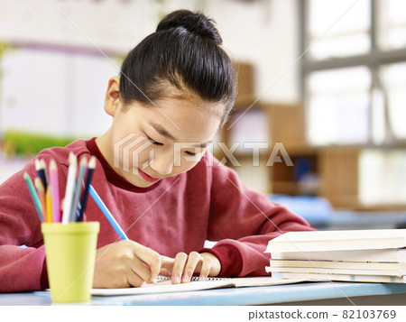 asian primary school student studying or doing homework in classroom. asian primary school student studying or doing homework in classroom. 82103769