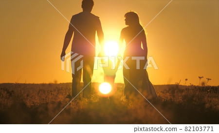 A small child walks with mom and dad at a bright sunset in the sky. Meet the sunrise with your family while traveling. Go hiking with your mother and father. Kid and loving parents walk in the park A small child walks with mom and dad at a bright sunset in the sky. Meet the sunrise with your family while traveling. Go hiking with your mother and father. Kid and loving parents walk in the park 82103771